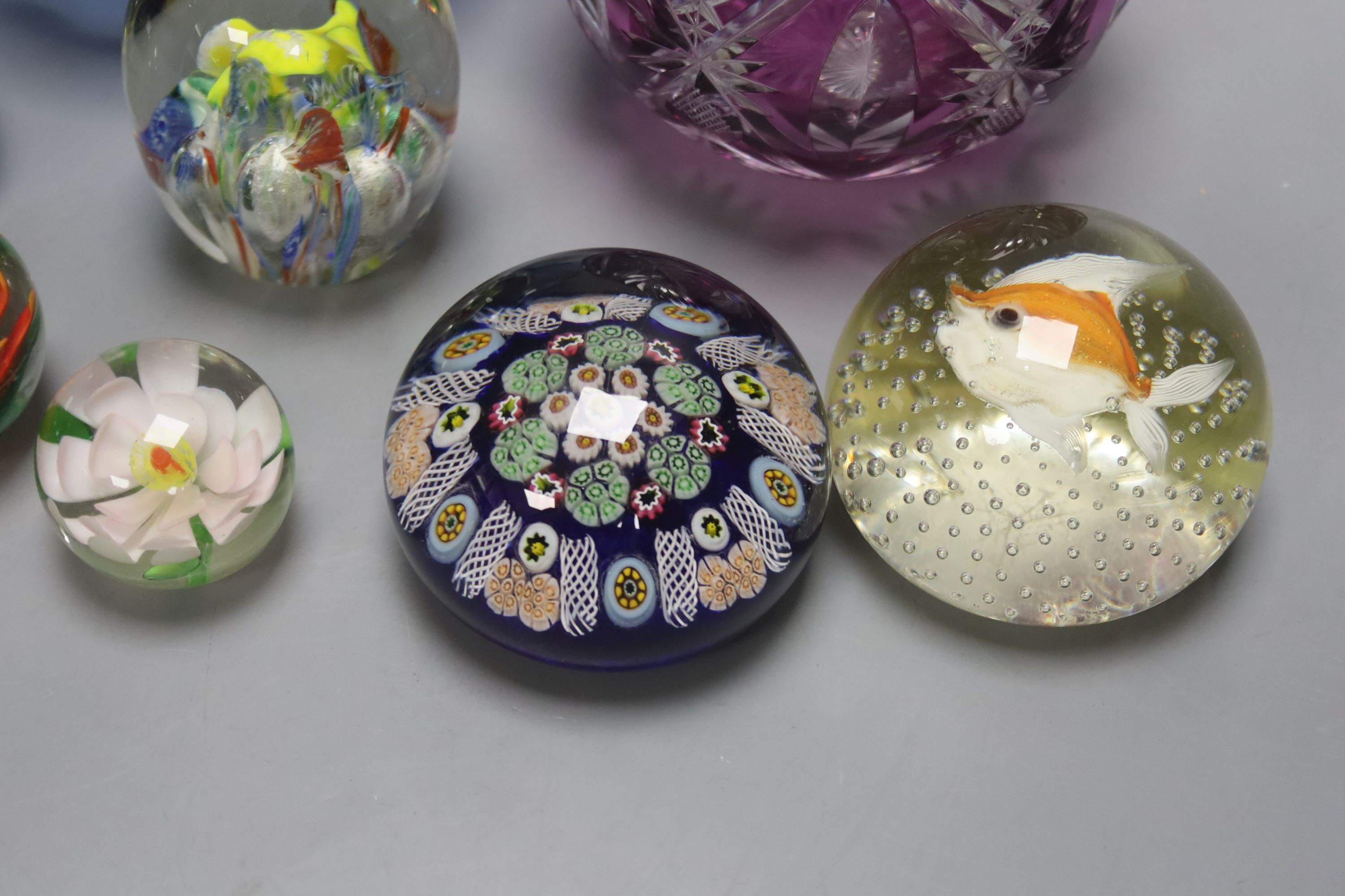 A group of coloured glassware including paperweights